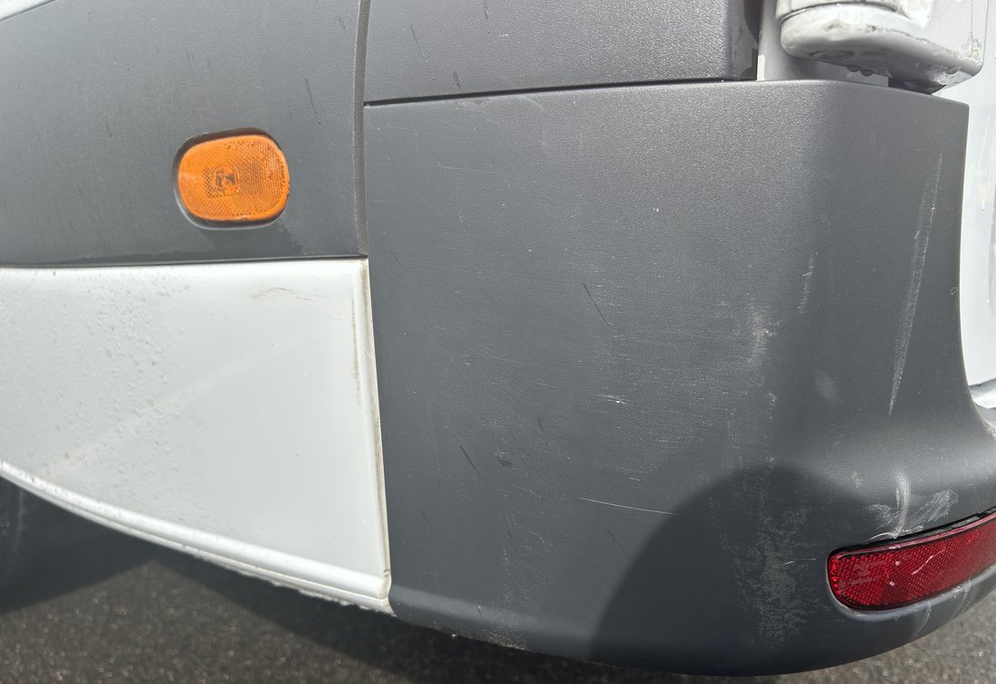 Eingedrückte hintere Stoßfängerecke eines weißen Mercedes-Benz Sprinter Kastenwagens, Schadengutachten über 3.377,69 €