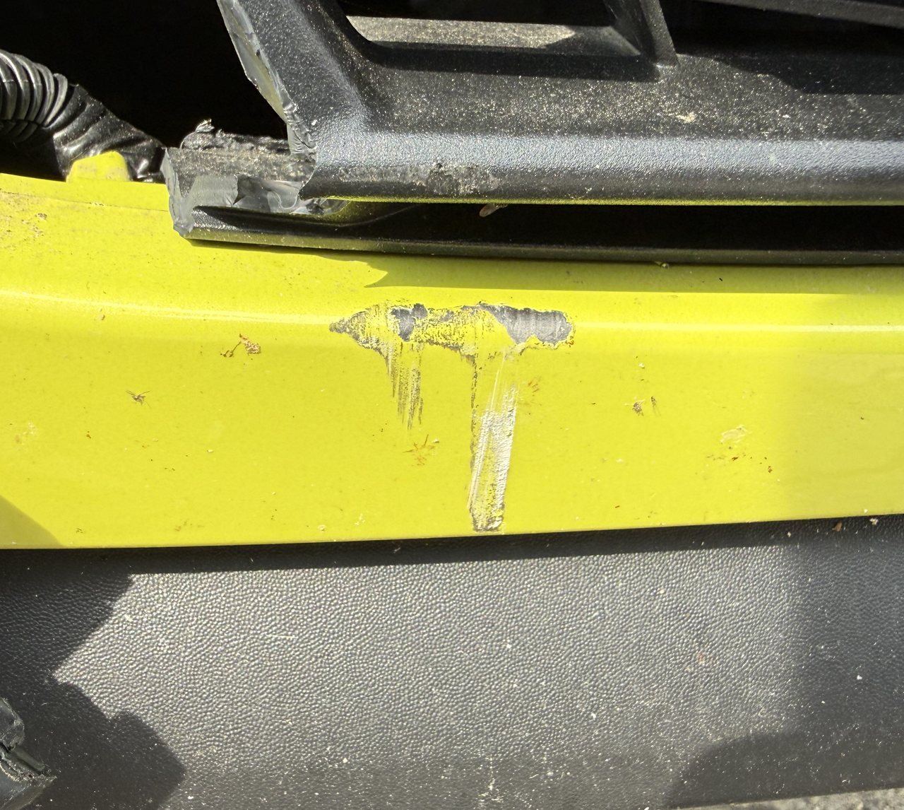 Frontstoßfänger eines Peugeot e-208 mit weißen Lackantragungen des Unfallgegners, aufgenommen bei der Schadenbesichtigung